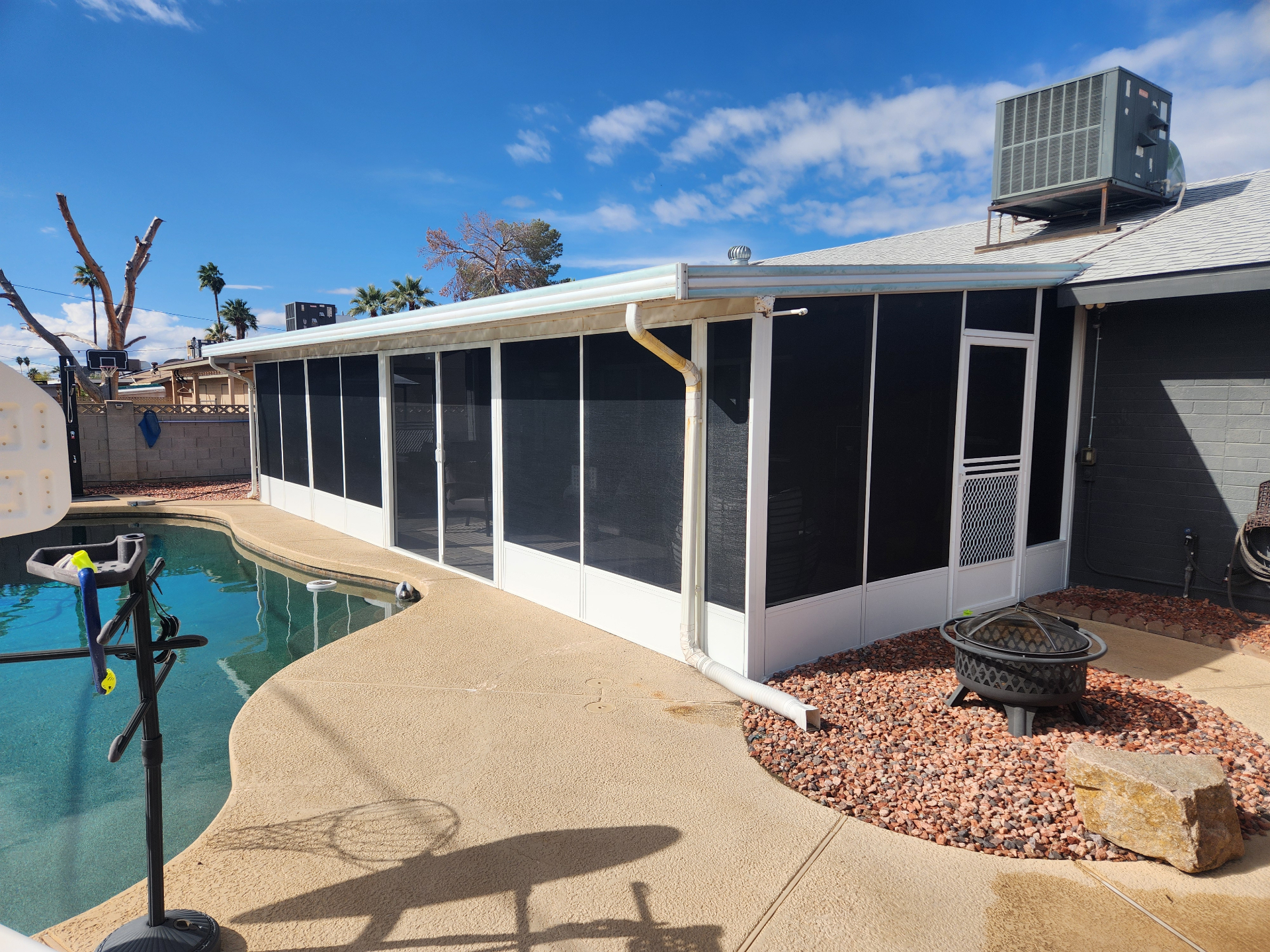 Patio enclosure with sun screens by pool