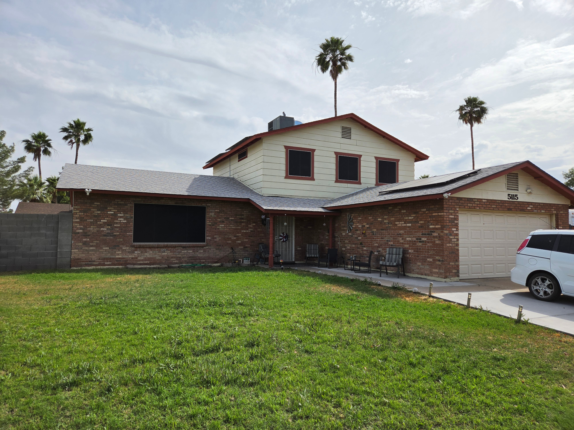 Brick home with black sun screens installed